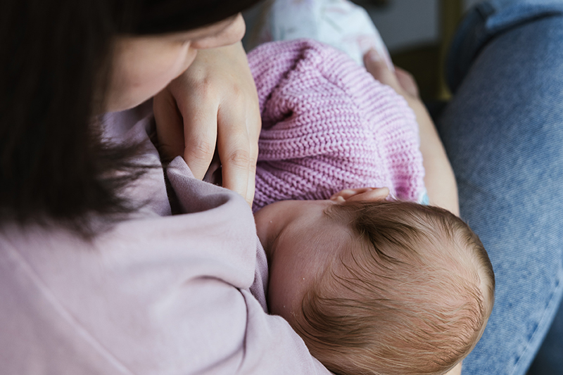 Close up of a baby feeding on a mother's breast